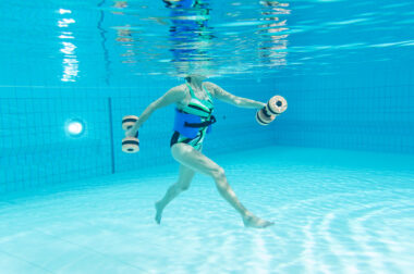 Eine Person Unterwasser, die eine Hantel benutzt