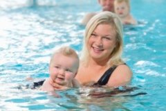 Person mit Baby im Wasser