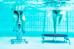 Die Beine zweier Personen auf Sportgeräten, Unterwasser