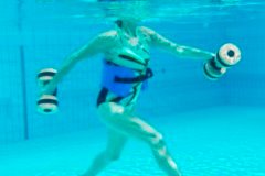 Eine Person Unterwasser, die mit Aquahanteln trainiert