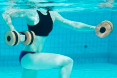 Eine Person Unterwasser, die eine Hantel benutzt