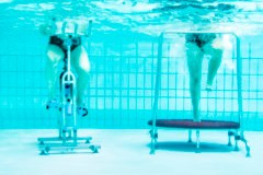 Die Beine zweier Personen auf Sportgeräten, Unterwasser