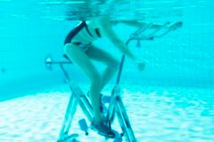 Zwei Personen Unterwasser, die auf Aqua Bikes trainieren